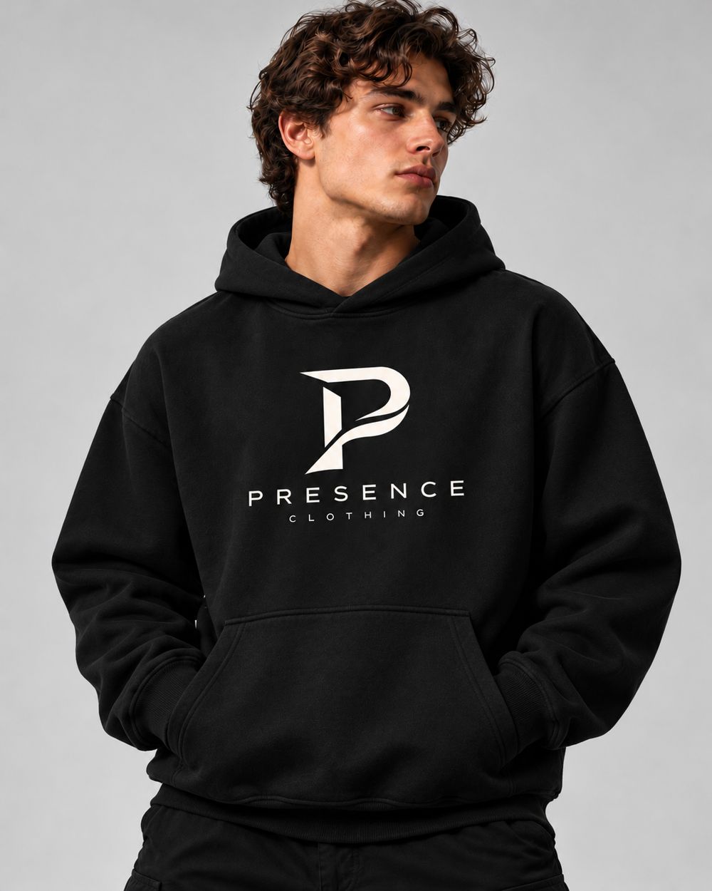 Man in the black Presence Hoodie, hands in pocket